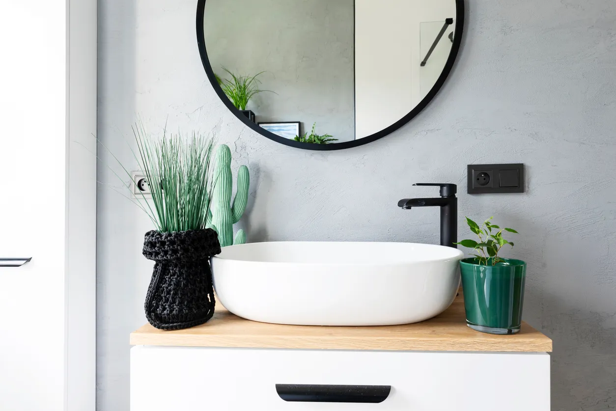 Lavabo de cerámica sobre mueble de baño. Interior de estilo industrial en un loft.