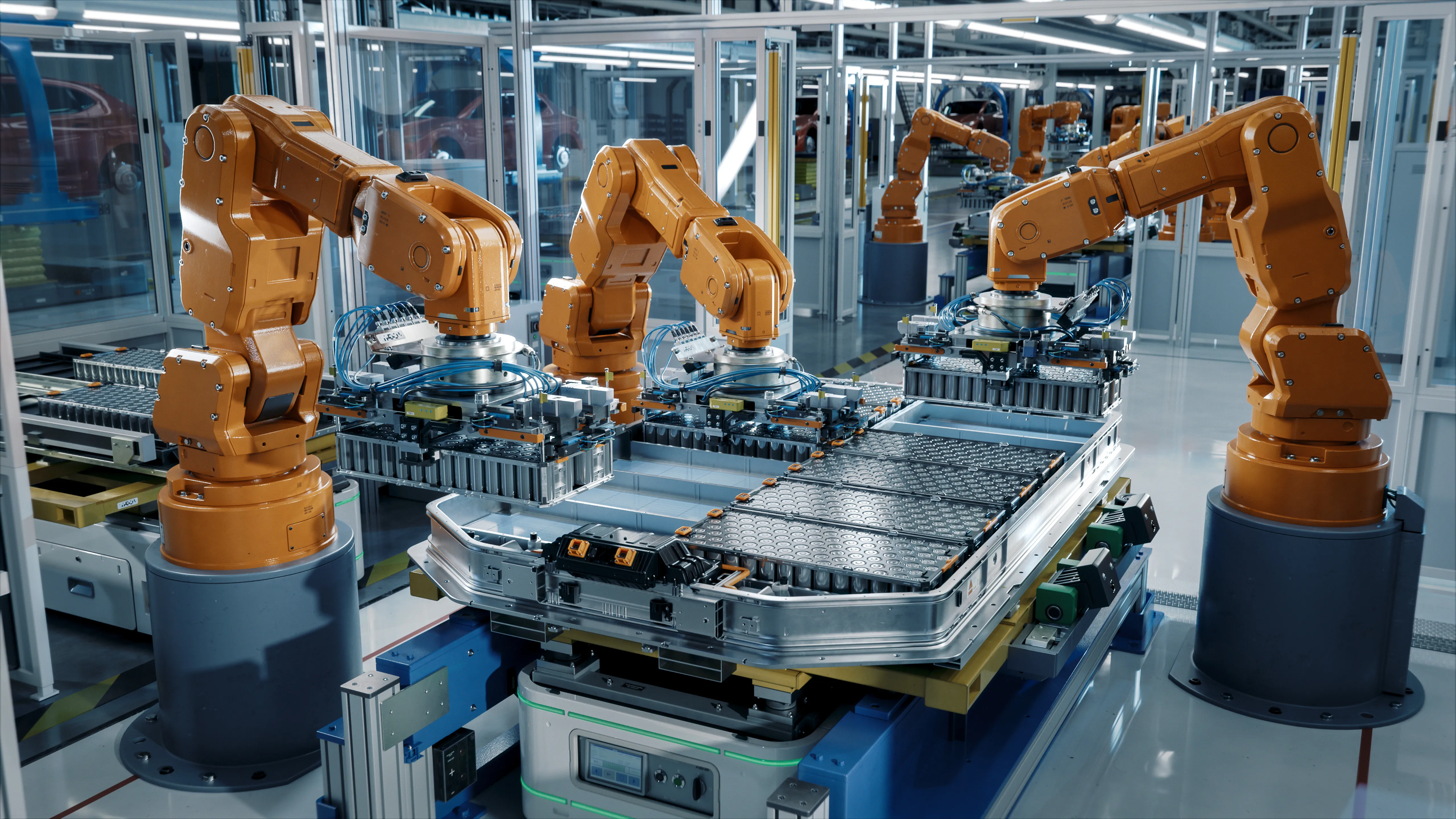 Brazos robóticos industriales  ensamblan baterías de vehículos eléctricos en una línea de producción.
