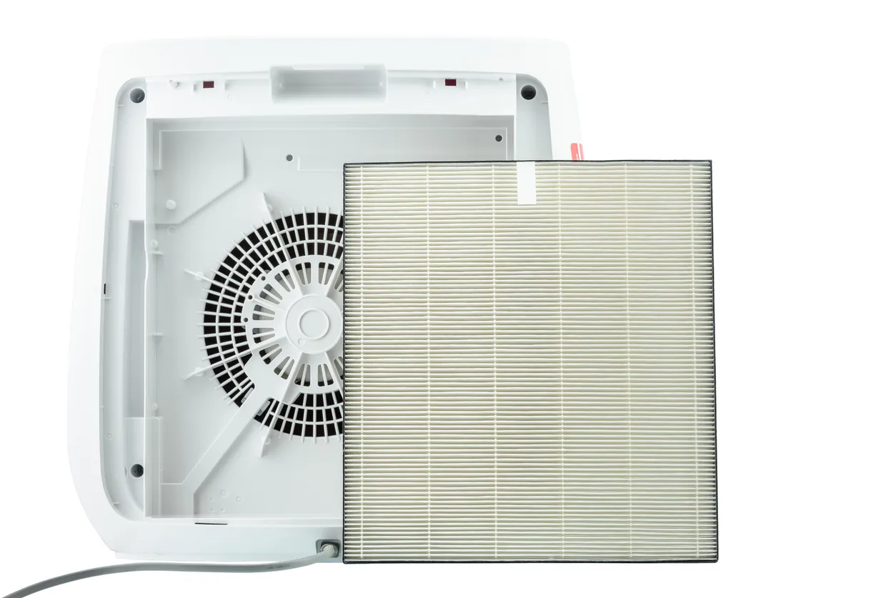 Vista trasera del ventilador del purificador de aire con filtro HEPA de repuesto, aislado sobre fondo blanco.