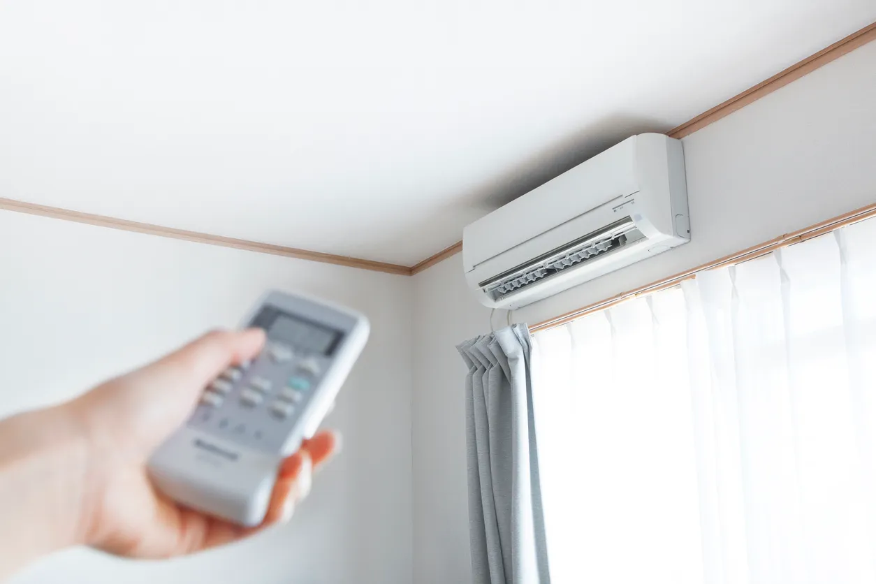 Mano con control remoto dirigida al acondicionador