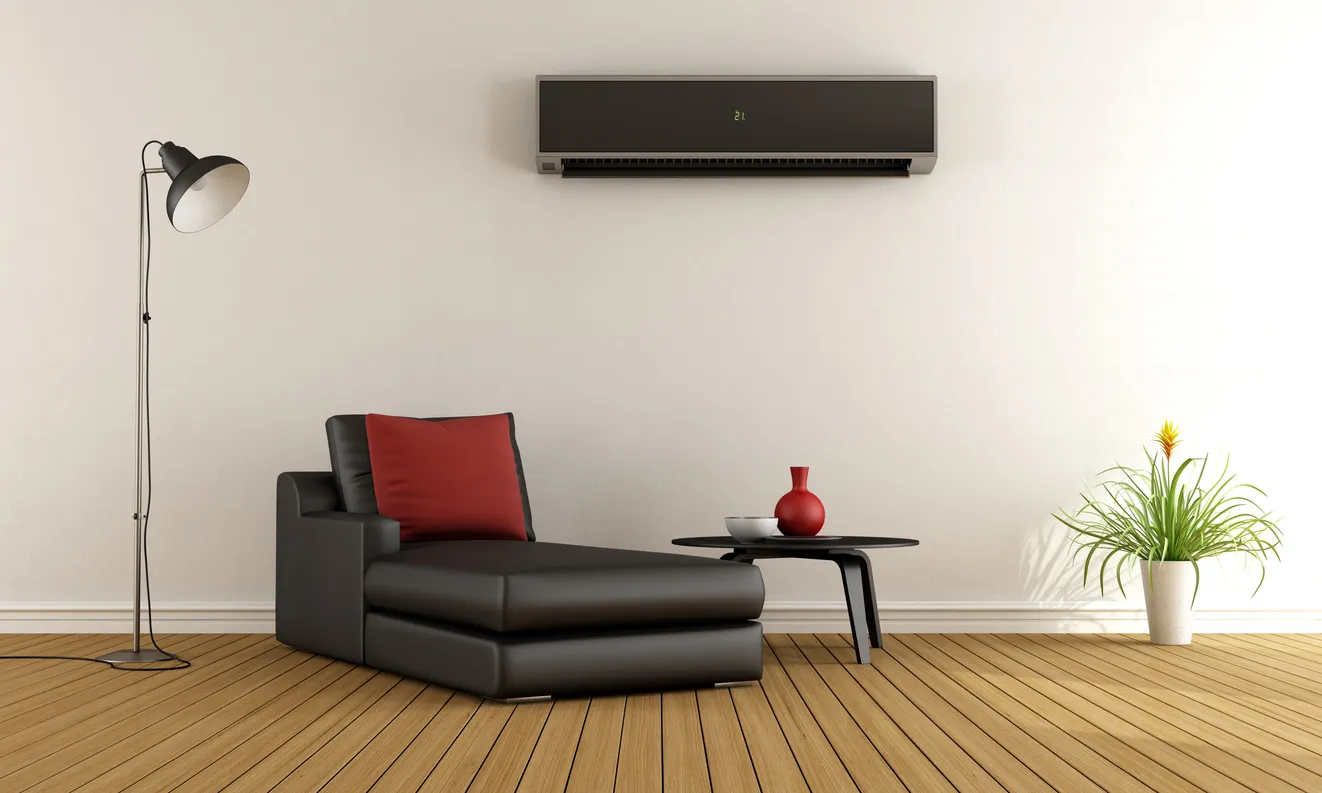 Sala de estar minimalista con sofá y aire acondicionado en color negro en la pared.