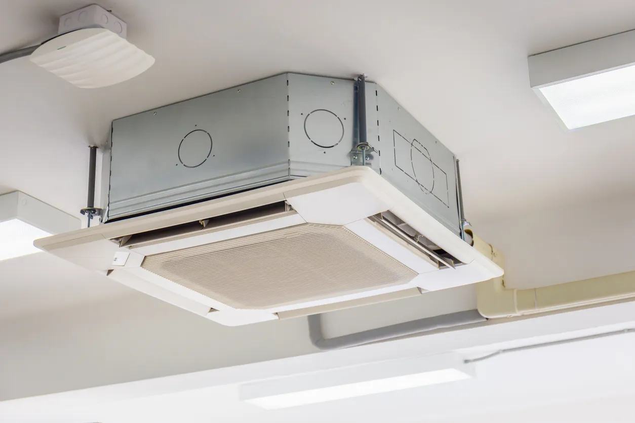 Moderno sistema de aire acondicionado tipo cassette montado en el techo de la habitación.