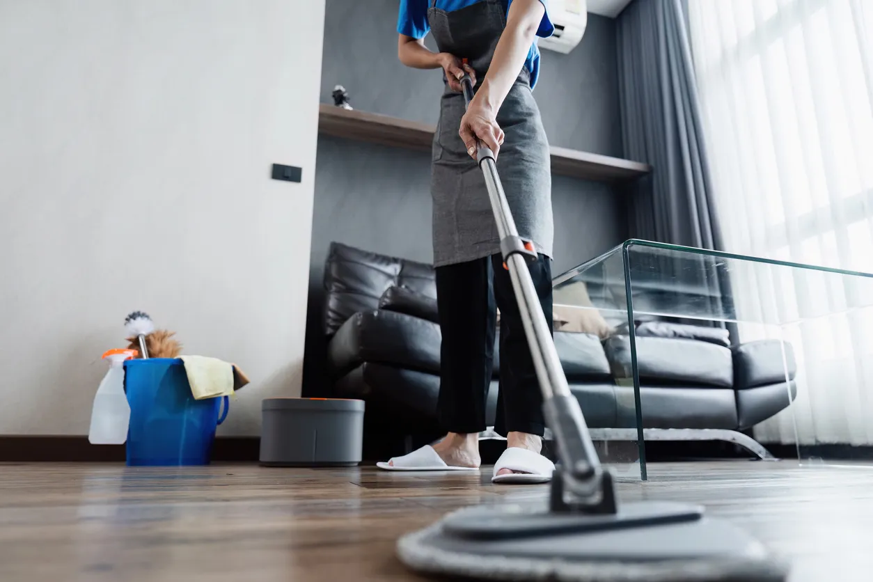 Servicio de limpieza: una empleada doméstica limpia el suelo de la sala