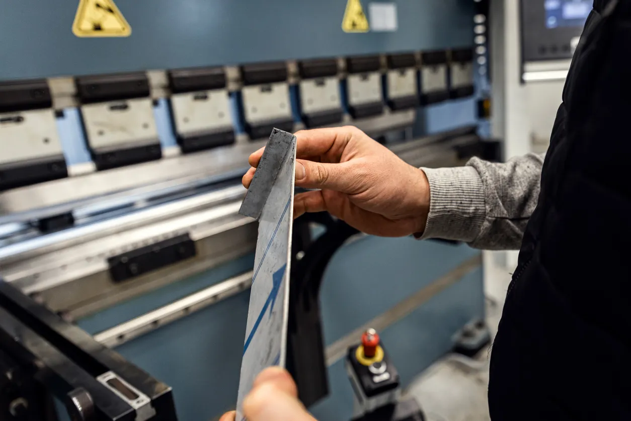 Operador en doblado de chapa metálica en fábrica
