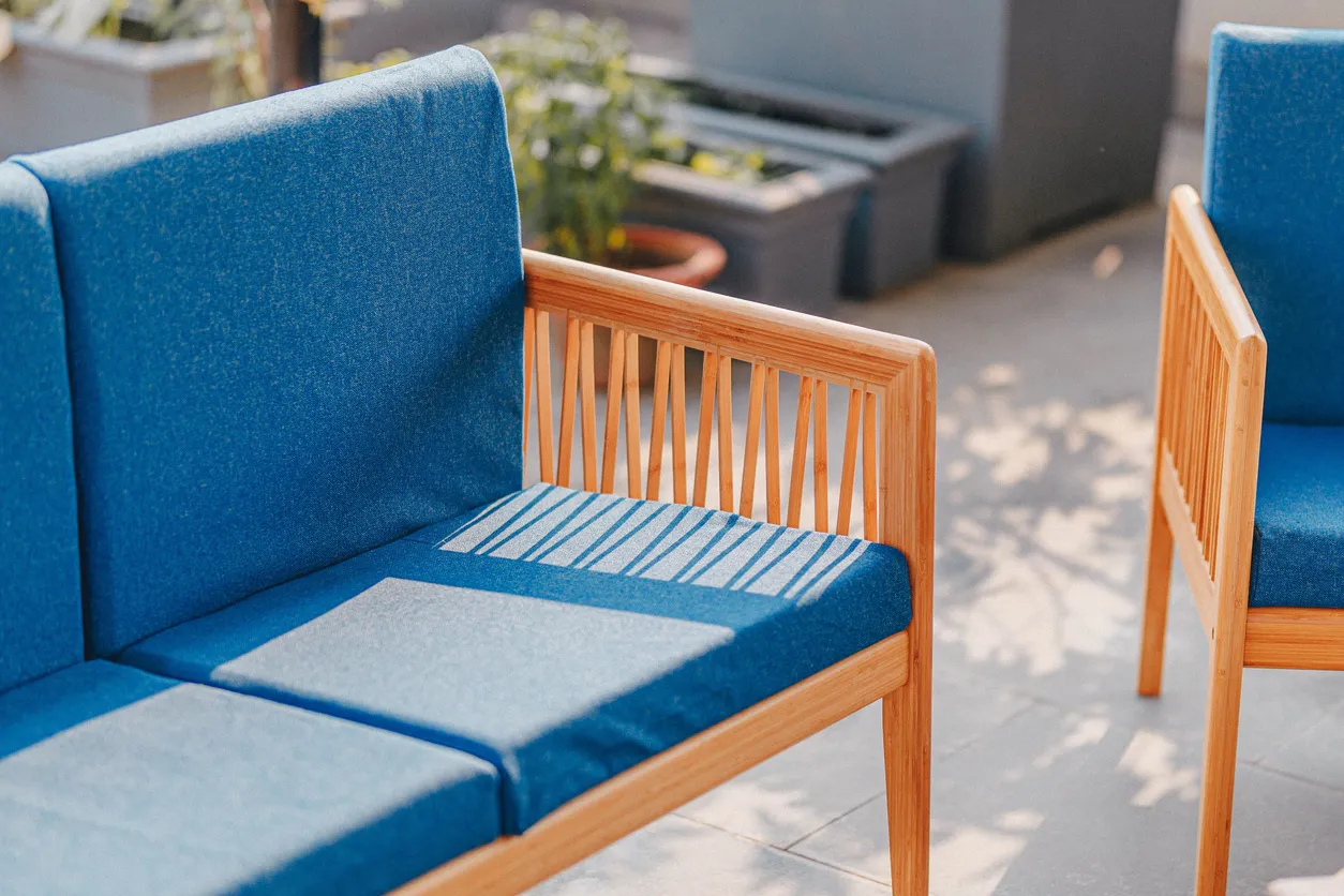 Primer plano de un sofá y una silla azules a la luz del sol