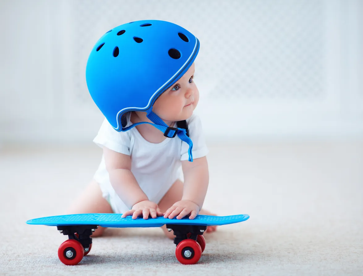 Una adorable bebé con casco protector, lista para patinar y practicar deportes