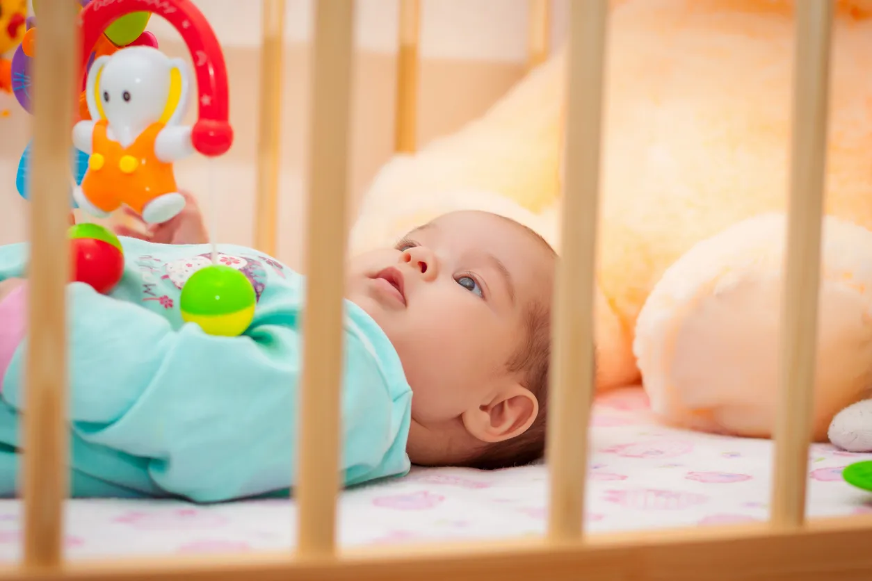 bebé con juguetes para cuna aptos para su edad
