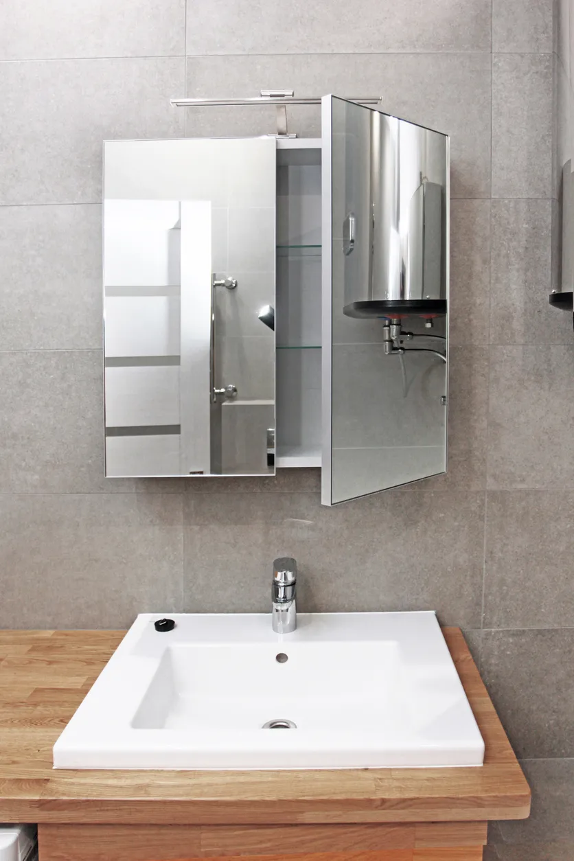 Gran boutiquin con luz led y espejo y un mueble de madera con lavabo blanco 