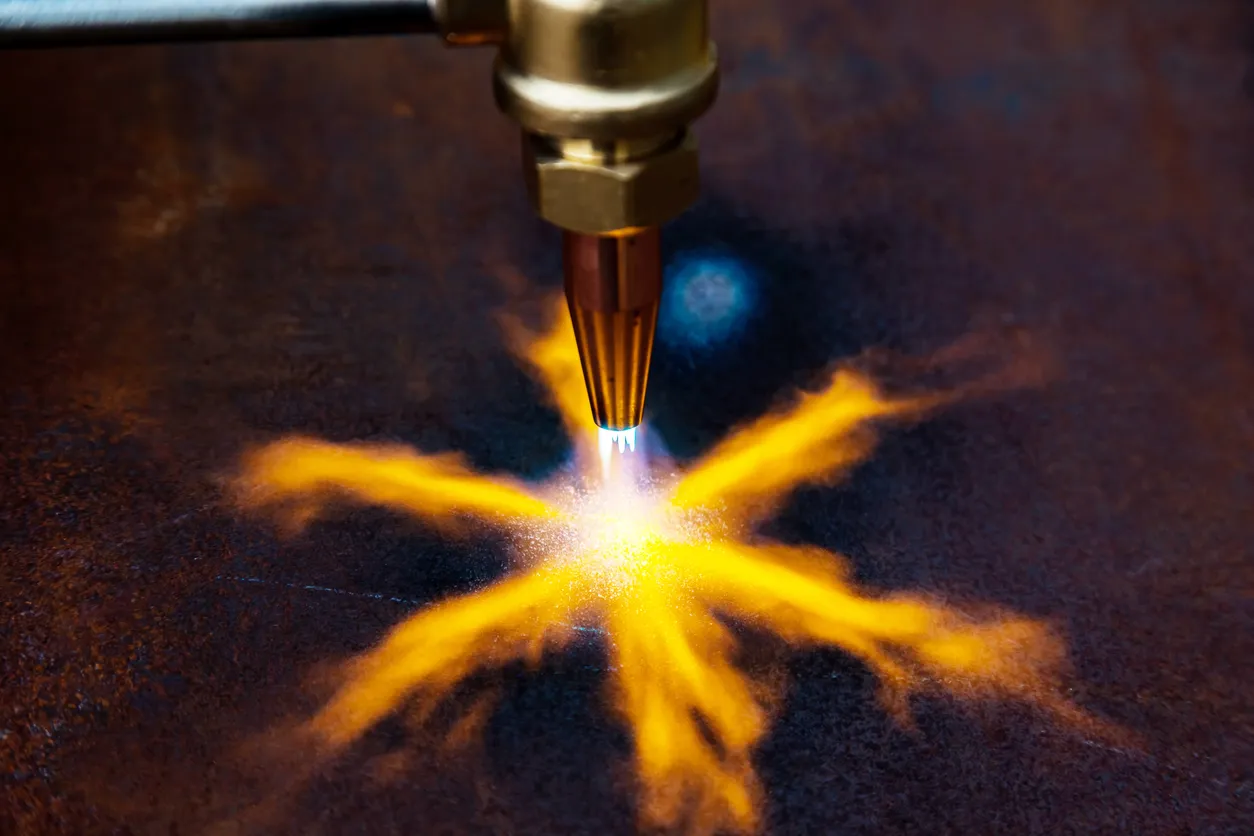 Corte de metal con gas. Cortadora de gas con boquilla de cobre que dirige un chorro de fuego al metal.