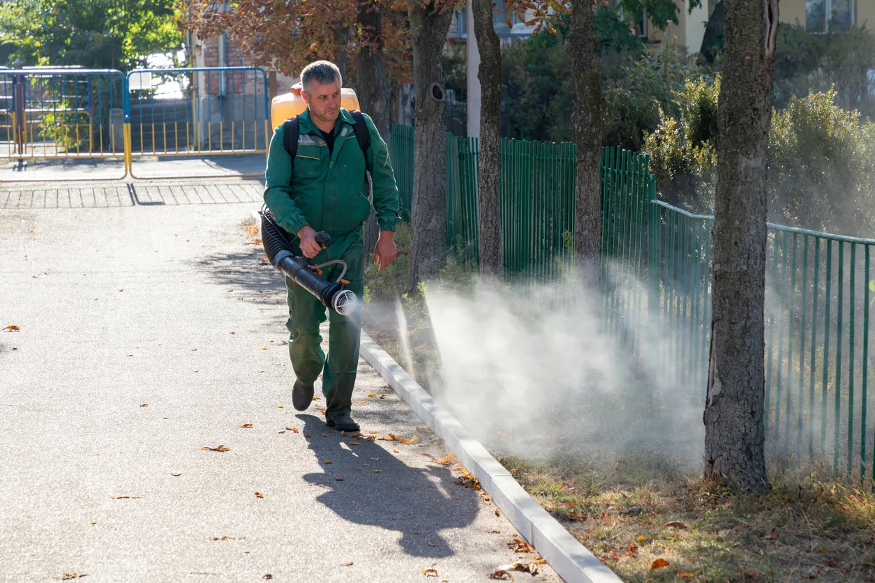 El trabajador rocía el territorio con insecticida para mosquitos o plagas o herbicidas para malezas