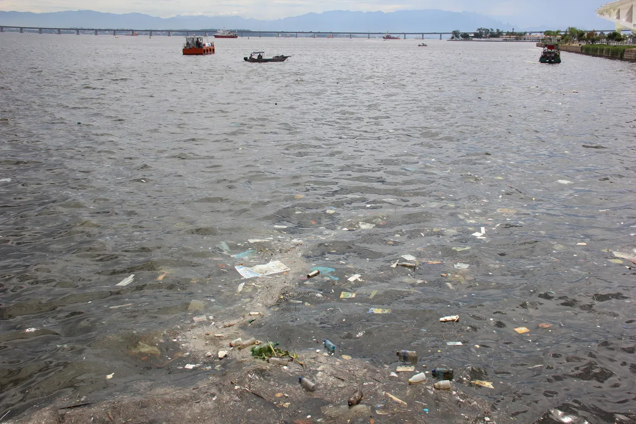 Enorme lago con basura visible. La zeolita adsorbe nutrientes y metales para restauración ecológica