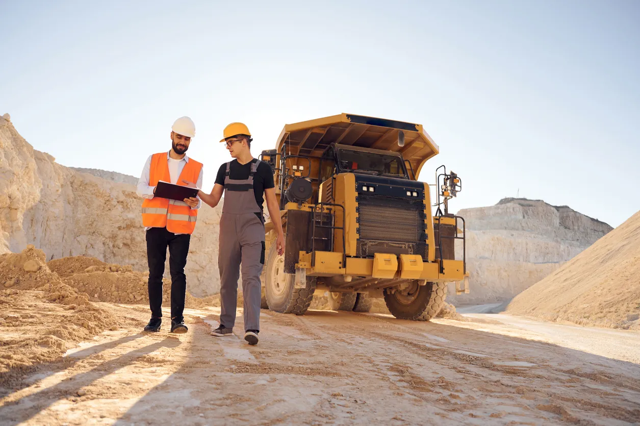 Dos hombres uniformados trabajan juntos en la cantera.La zeolita ayuda al control de metales y aguas ácidas.
