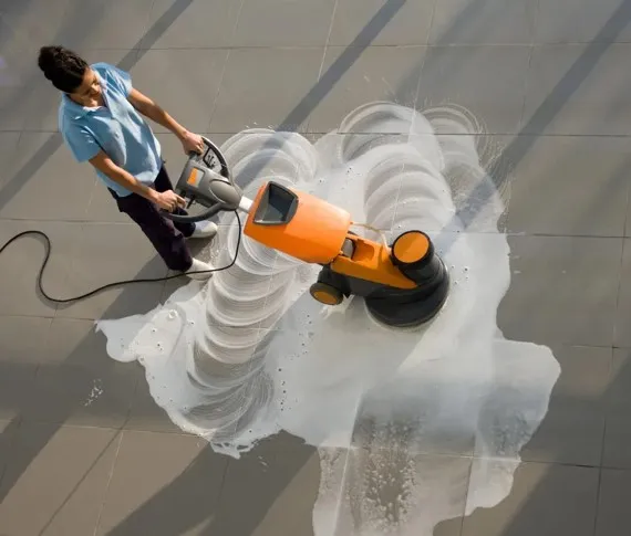 Persona puliendo los pisos de una planta industrial