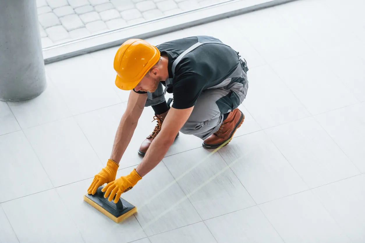 Trabajador realizando la limpieza del piso de una construcción recién concluída