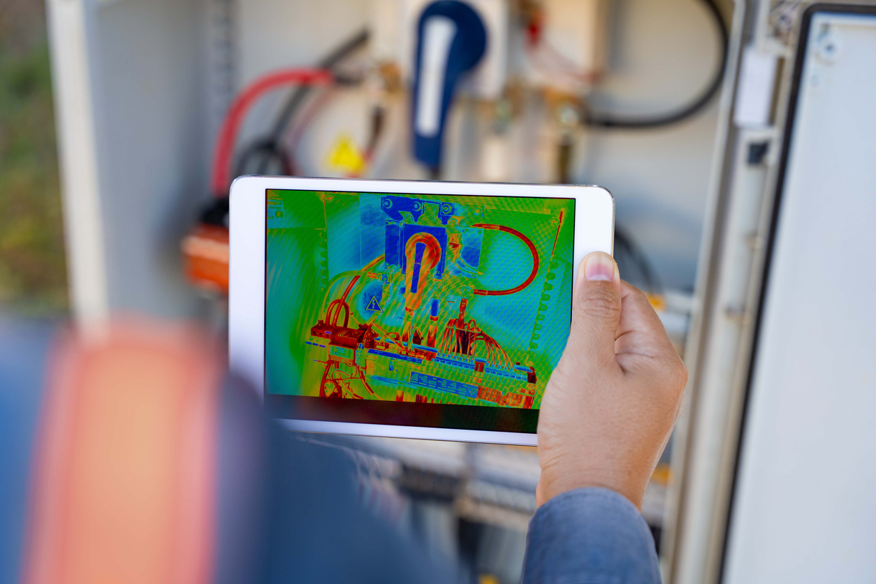 Los técnicos están verificando la temperatura del panel solar en la planta de energía solar para que la generación de energía