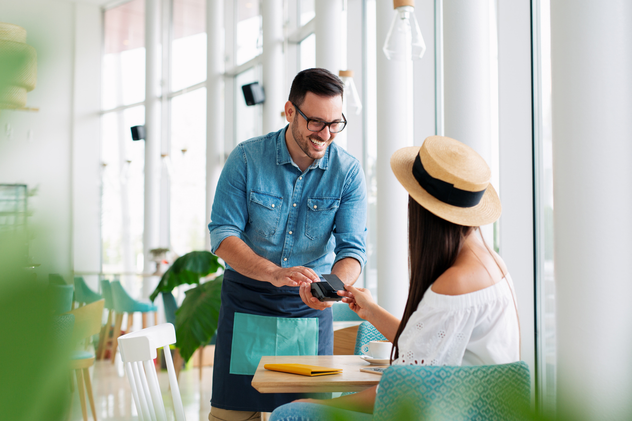 Mujer pagando con tarjeta de crédito en el restaurante
