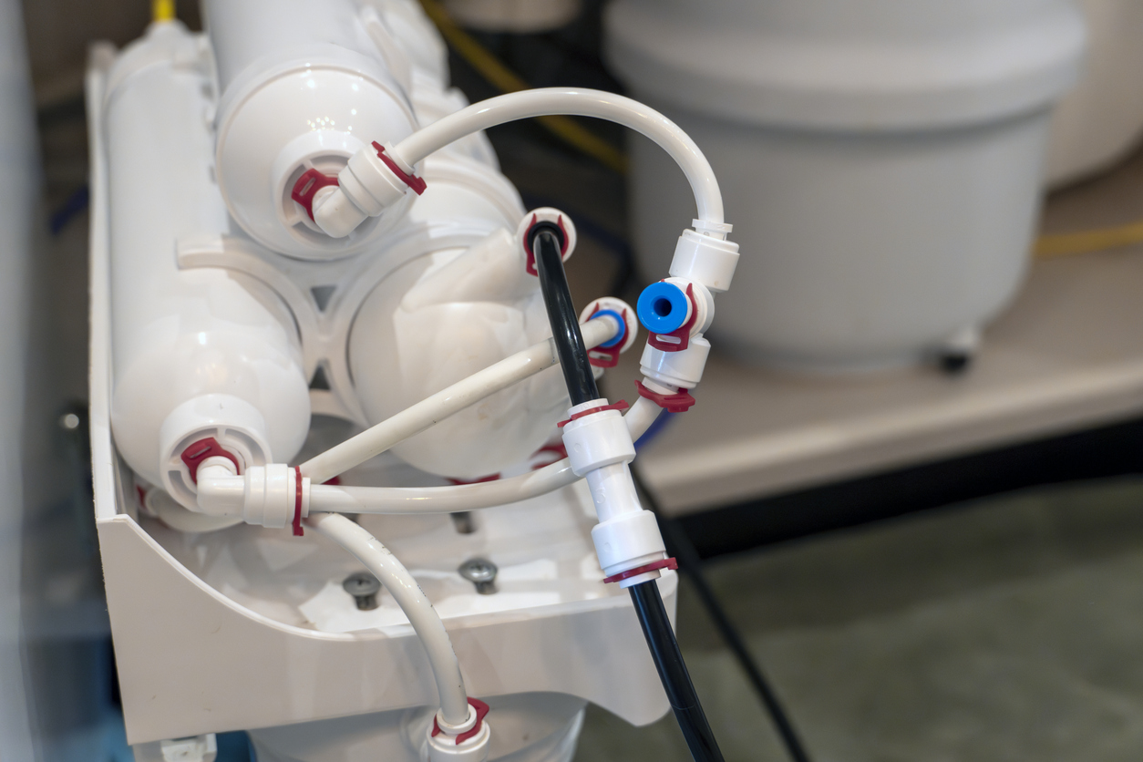 Primer plano del sistema de filtración de agua por ósmosis inversa con múltiples cartuchos,