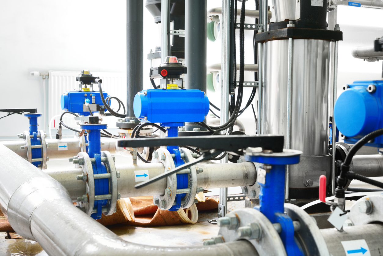 Tratamiento de agua industrial grande y sala de calderas. Pipas de metal acero brillantes y azul bombas y válvulas