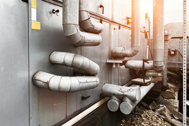 Técnico de servicio de aire acondicionado, HVAC que utiliza medidores para verificar el refrigerante y agregar refrigerante.