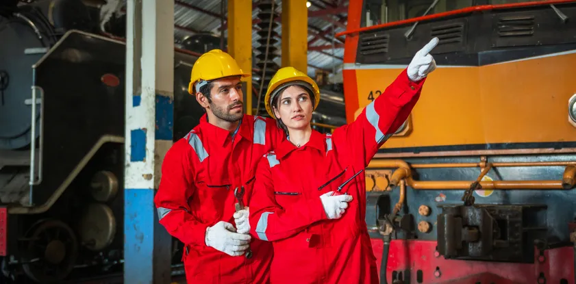 Obreros con overol naranja de seguridad labaorando en industria