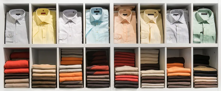 tienda con una gran cantidad de camisas de vestir de diversos colores y en la parte inferior playeras modernas 