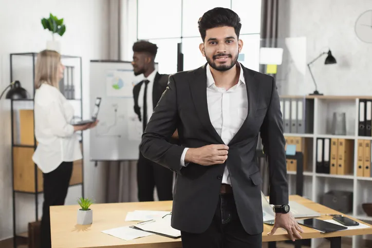 Hombre joven con camisa blanca de vestir y saco en oficina moderna