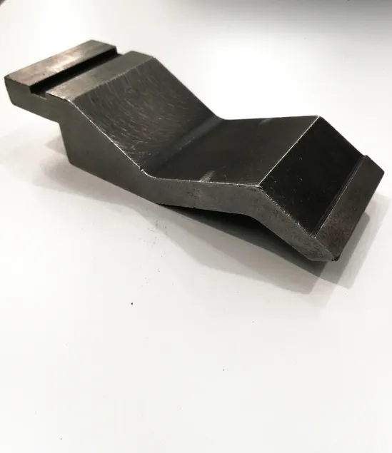 Detalle de un punzón de prensa plegadora sobre fondo blanco, concepto de herramientas de trabajo