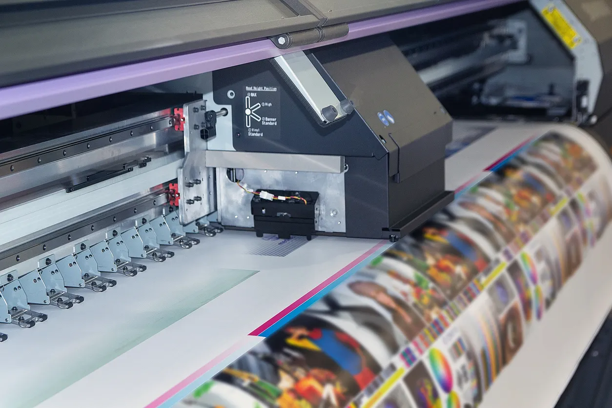 Máquina de impresión de gran formato en funcionamiento. Ejemplos de materiales de promoción