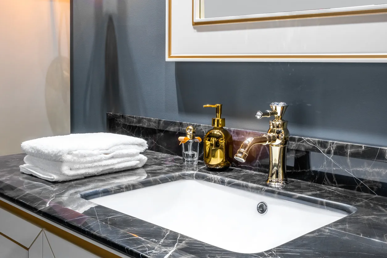 Interior de baño con lavabo y grifo dorado. Accesorios para baños 
