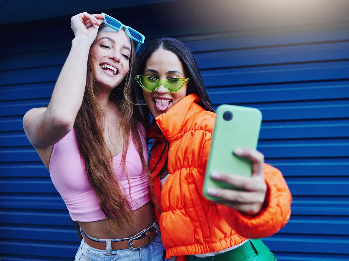 Par de amigas tomandose fotos con su celular de gama media comprado desde un proveedor de market b2b