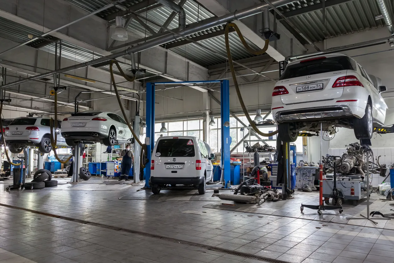 Taller de reparación de autos con mecánicos trabajando. El uso de equipos de aire lavado portátil son una opción eficiente.