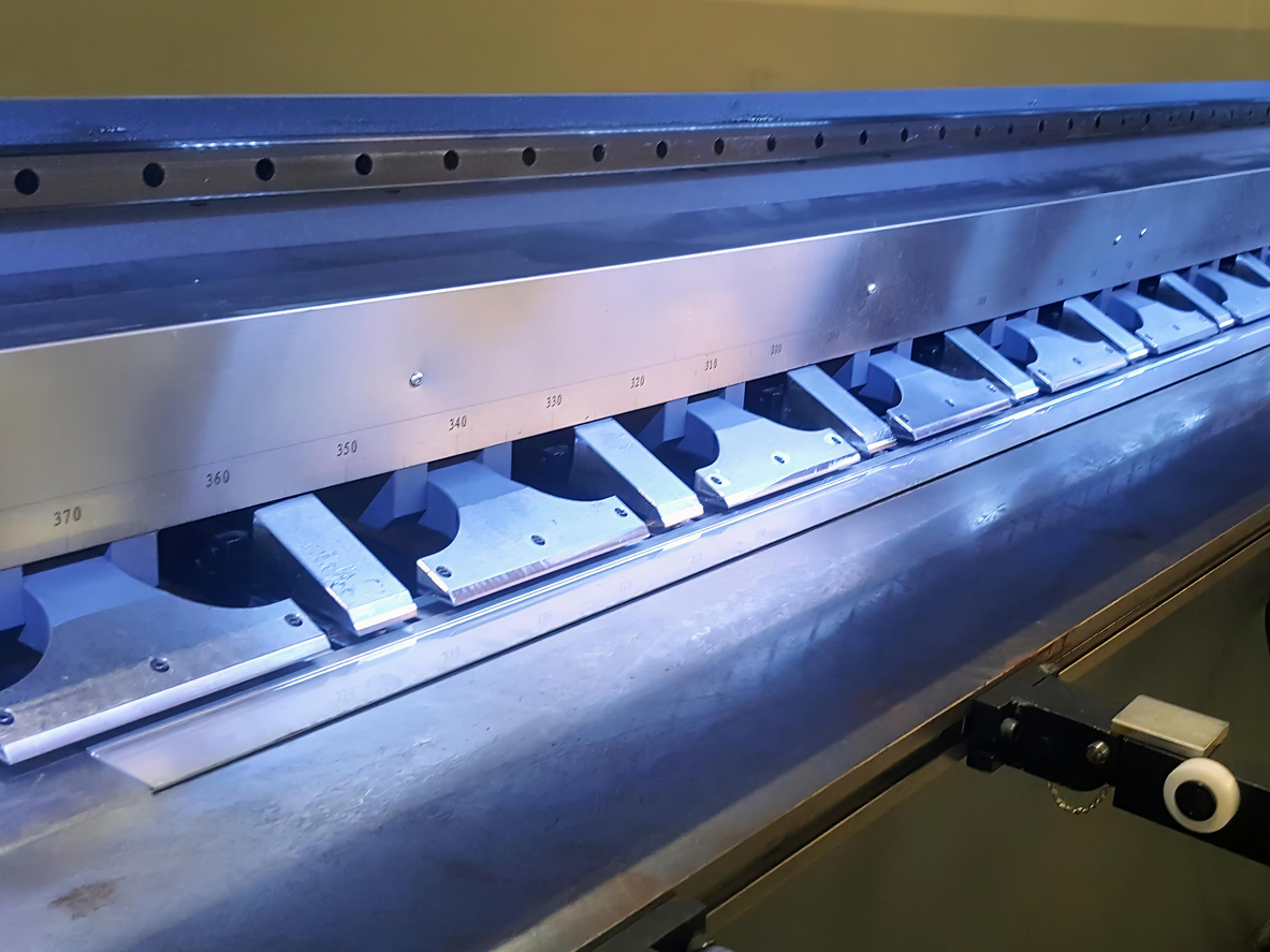 Una fotografía de una máquina que está cortando piezas metálicas