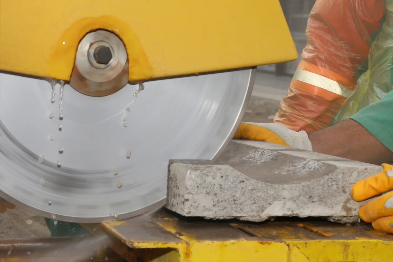 Trabajador cortando bloque de piedra con cortadora
