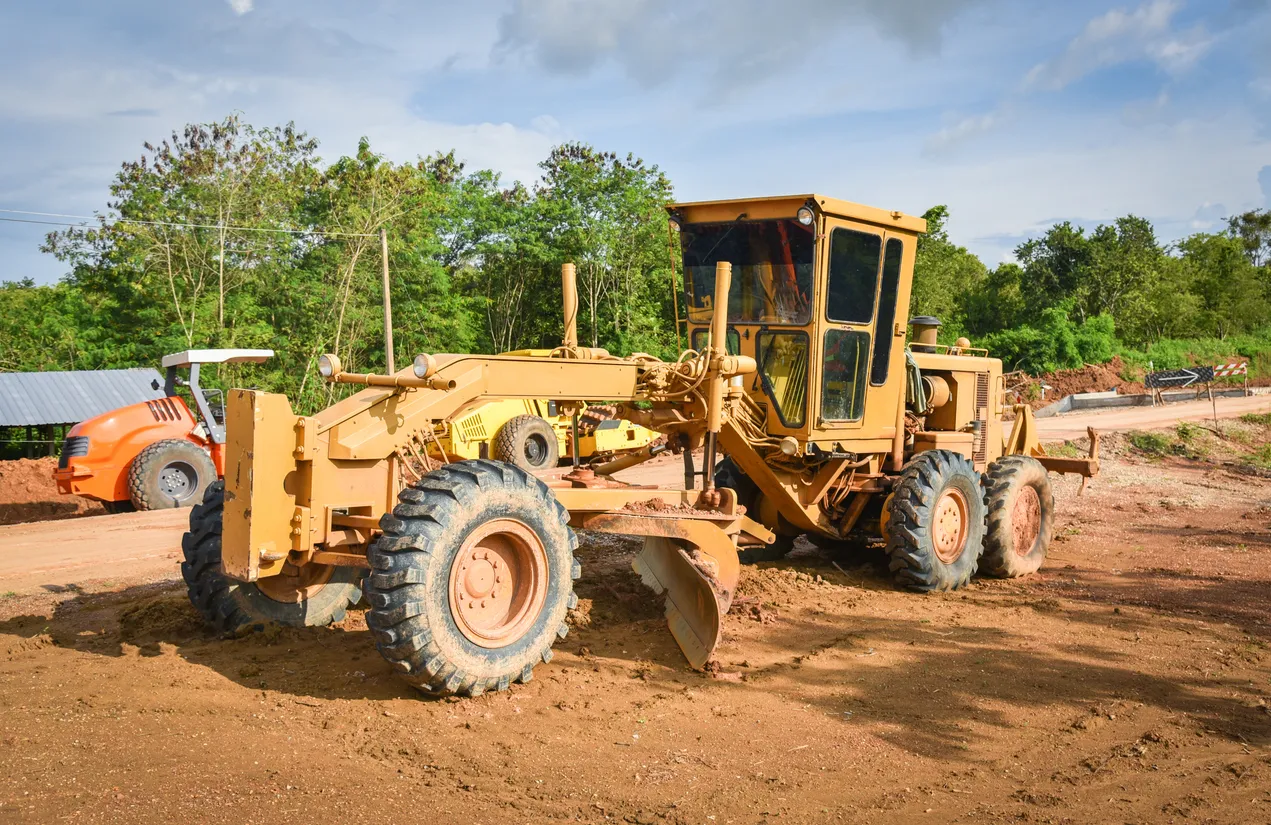 En el sitio de construcción, se utiliza un tractor nivelador de construcción para movimiento de tierras pesado.