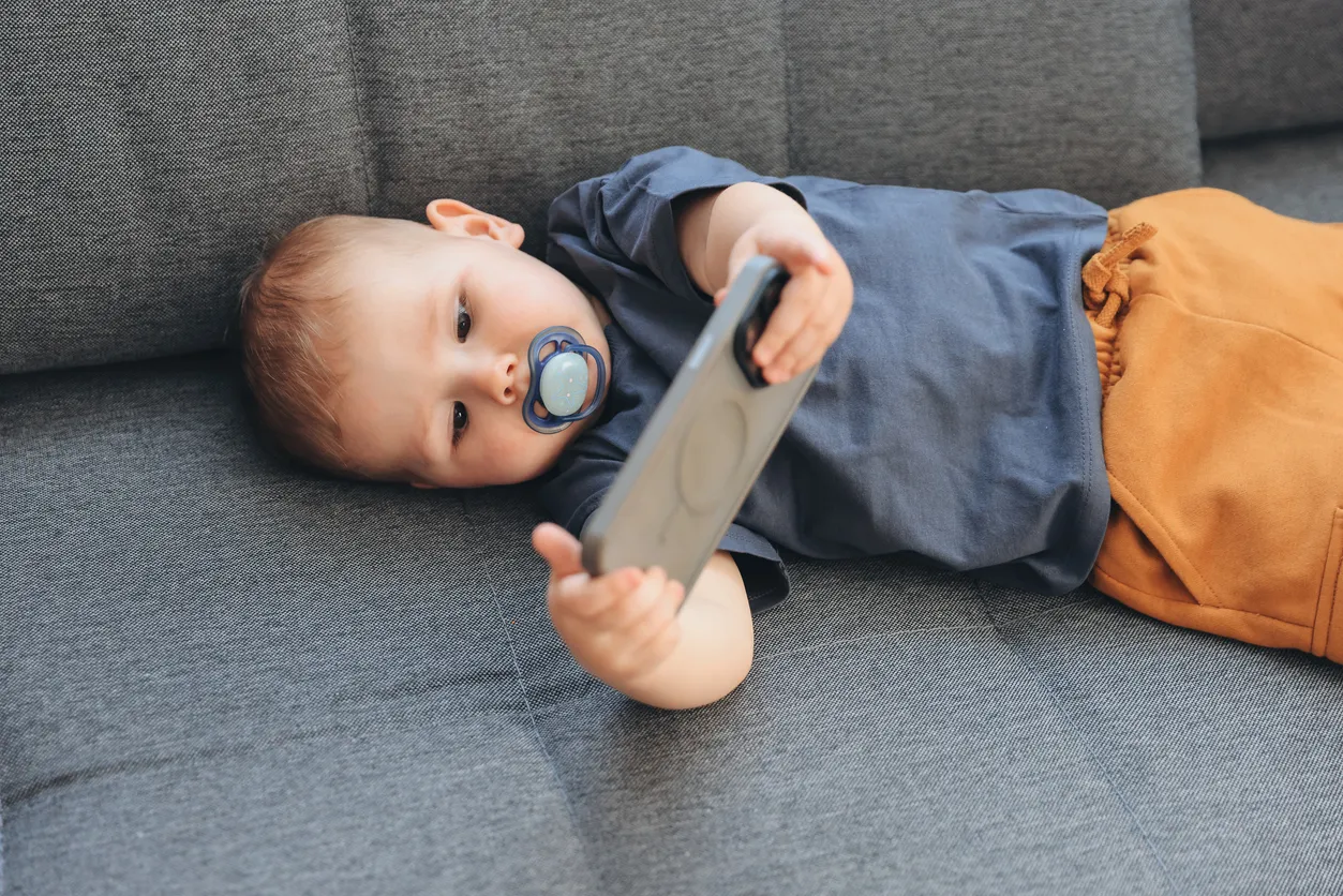 Nino recostado en un sillón con un chupon en la boca