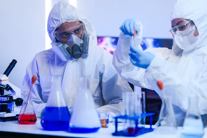 dos químicos con traje y equipo de protección