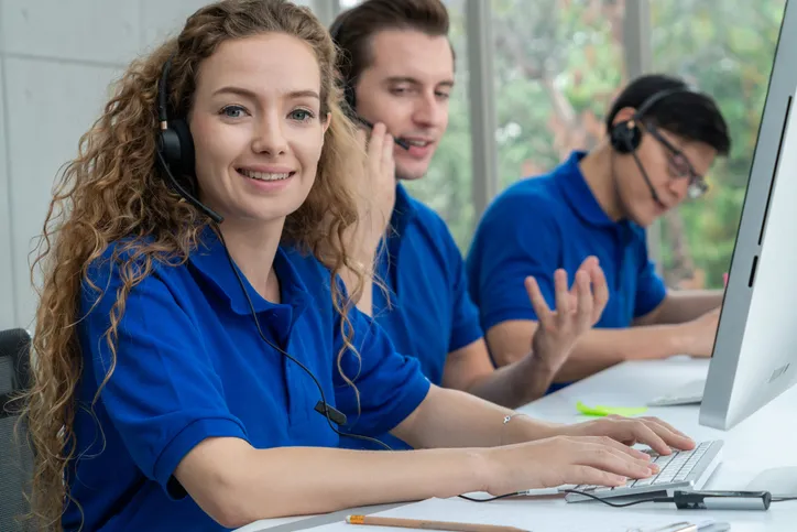 Varios jovenes en área de atención a clientes con playera tipo polo color azul