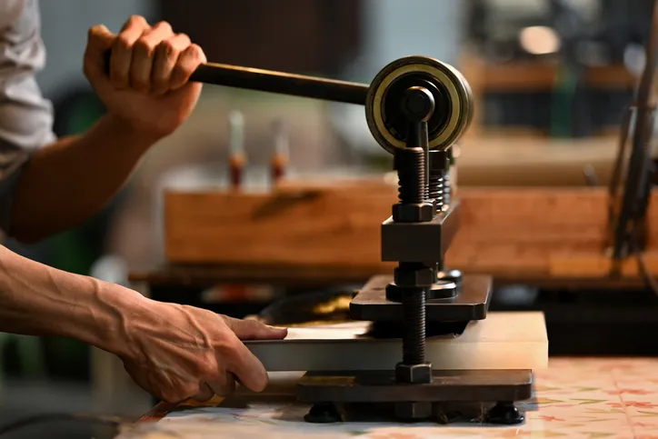 artesano máquina de prensa de hierro en taller de cuero