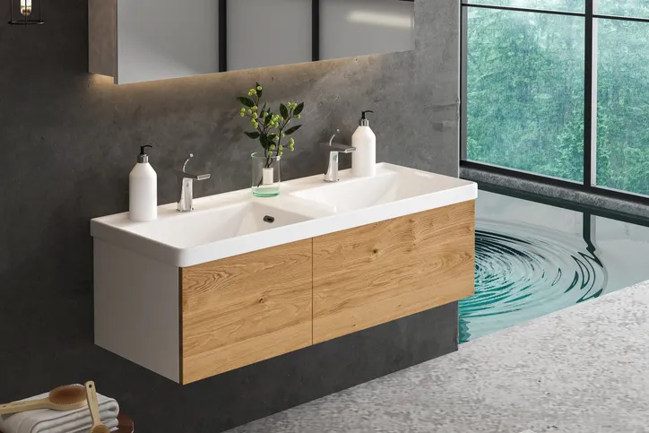 Lavabo de baño blanco sobre un mueble de baño de madera.