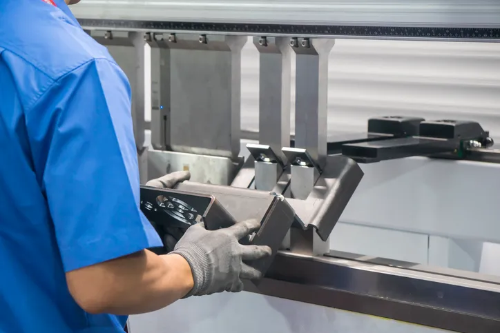 La operación de la máquina de flexión hidráulica del freno de prensa, doblando el automotriz por el trabajador de habilidad