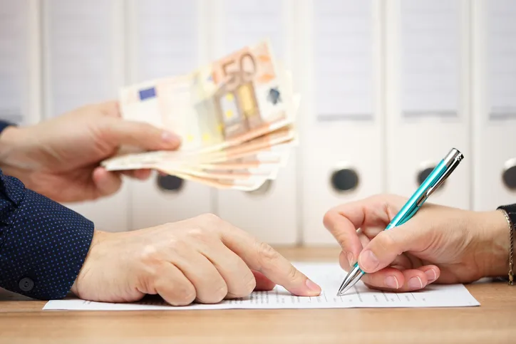 Empleado de nómina entregando un anticipo a otro empleado