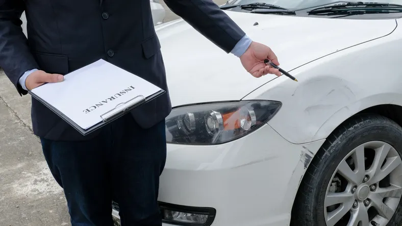 Agente de seguros ajustador de pérdidas que inspecciona el automóvil dañado. 