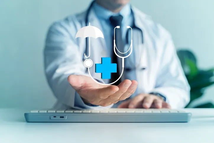 Médico ofreciendo símbolo de protección sanitaria con paraguas y estetoscopio, concepto de seguro médico