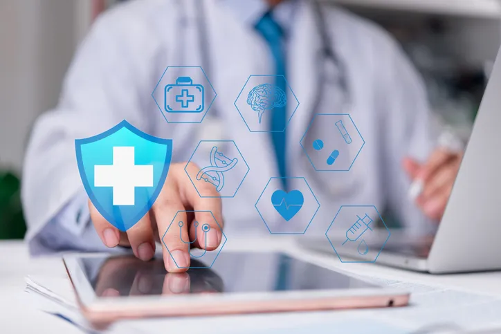 Elementos gráficos que representan a un seguro médico y al fondo un medico con bata blanca