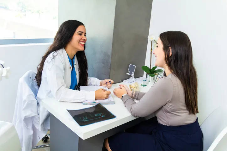 Una joven paciente y una doctora atiende a su paciente.