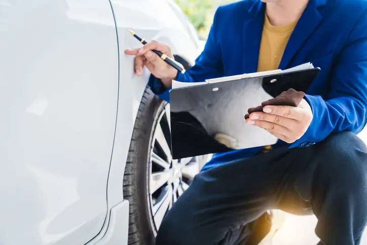 Un hombre de negocios en la demanda discute el reclamo con el agente de seguros de automóviles.