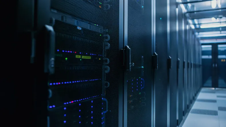 Primer plano de un centro de datos con filas de racks de servidores completamente operativos.