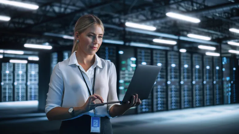 sala de servidores con administradora de sistemas trabajando con diversos indicadores entre los cuales están los de UPS