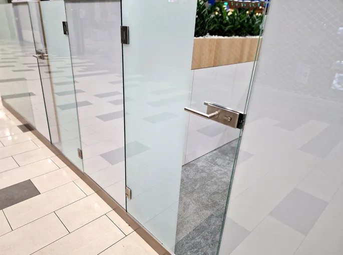 Puerta de vidrio sin marco. Los tabiques acristalados tienen bisagras y tiradores especiales.