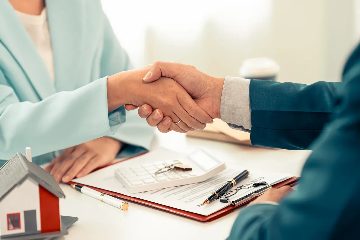 El representante de ventas de seguros estrecha la mano del cliente y negocia con éxito